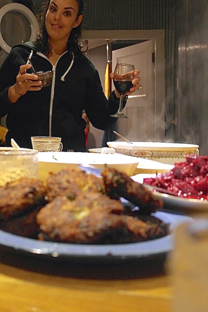 Potato cakes in the foreground. Jennee toasts her efforts in the background